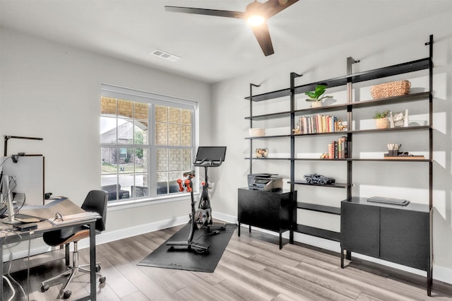 office space with ceiling fan, visible vents, baseboards, and wood finished floors