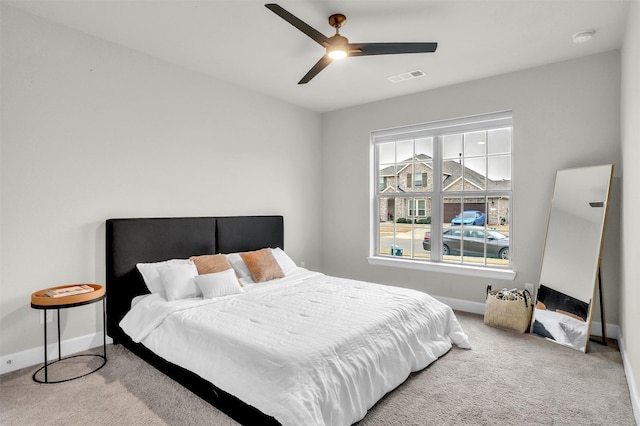 carpeted bedroom featuring visible vents, a ceiling fan, and baseboards