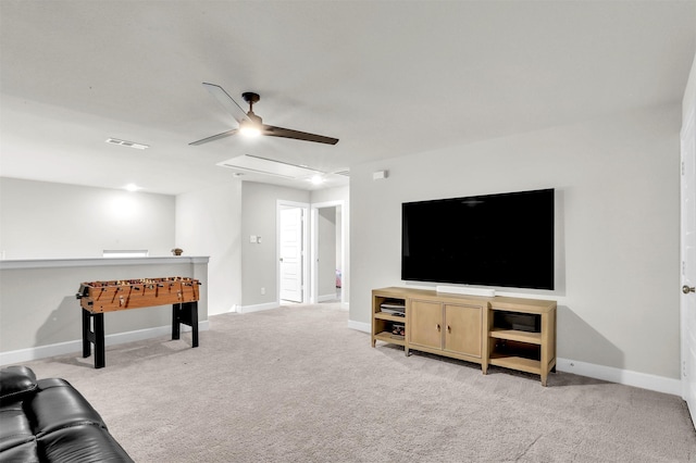 carpeted living room featuring visible vents, baseboards, attic access, and ceiling fan