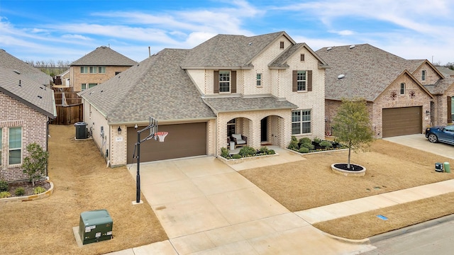 french country inspired facade with brick siding, concrete driveway, an attached garage, and a shingled roof