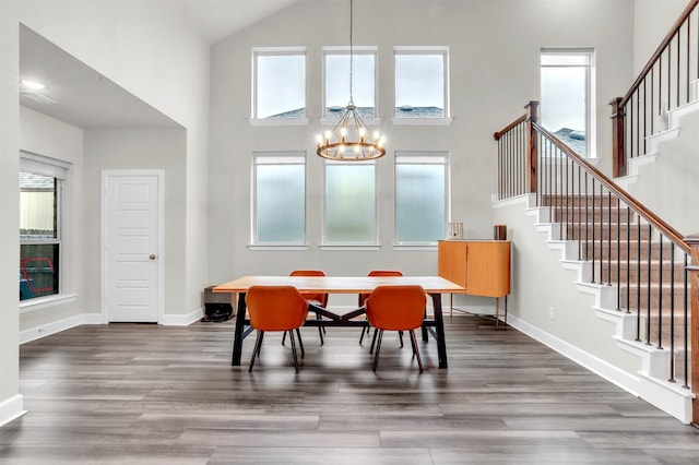 dining area with dark wood finished floors, stairway, a notable chandelier, and baseboards