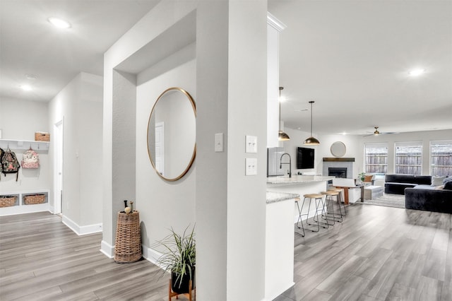 hallway featuring recessed lighting, baseboards, and light wood finished floors