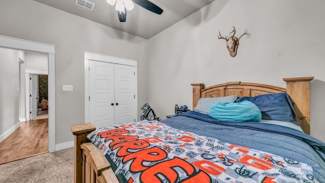 bedroom featuring visible vents, baseboards, light colored carpet, a closet, and a ceiling fan