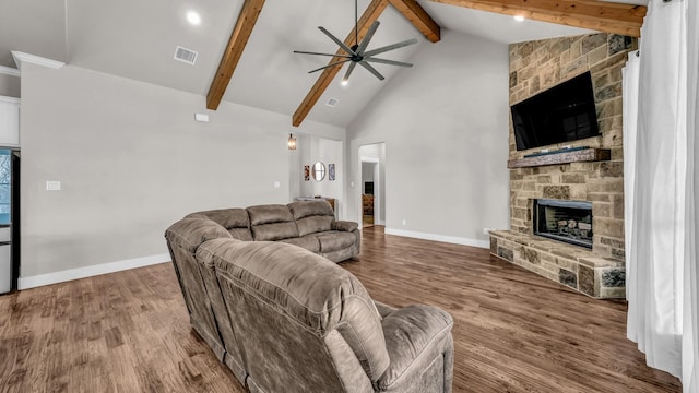 living room featuring wood finished floors, beamed ceiling, a fireplace, and visible vents