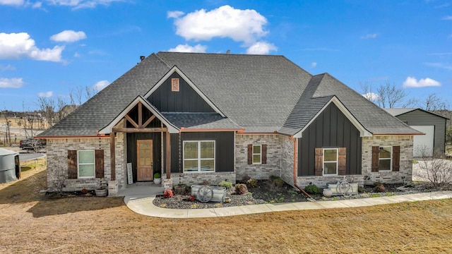 craftsman-style house featuring brick siding, board and batten siding, and a front yard