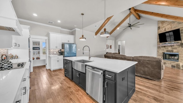 kitchen featuring premium range hood, a sink, stainless steel dishwasher, open floor plan, and white cabinetry