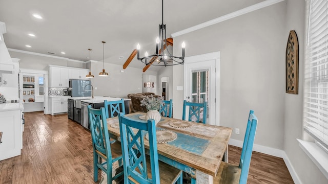 dining room featuring a chandelier, plenty of natural light, wood finished floors, and crown molding