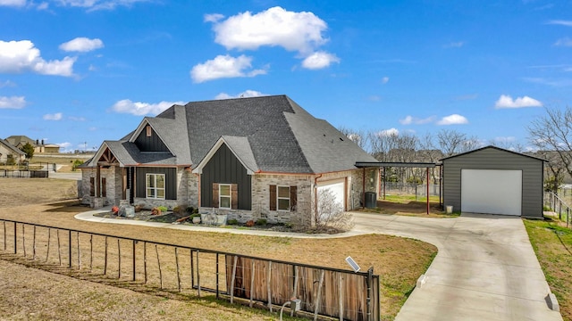 view of front facade with a detached garage, board and batten siding, a front yard, a shingled roof, and fence private yard