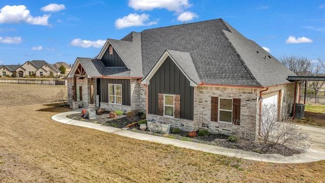 view of front of house featuring an attached garage, a shingled roof, concrete driveway, stone siding, and board and batten siding