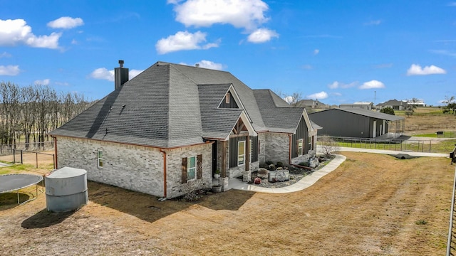 exterior space with a trampoline, fence, and a chimney