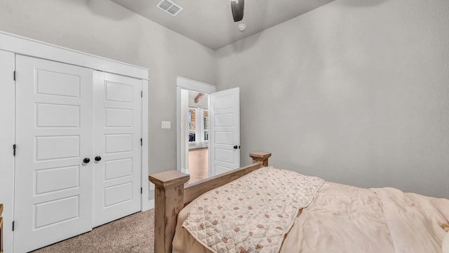 carpeted bedroom featuring visible vents, a closet, and ceiling fan