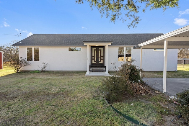 view of front of home with stucco siding, a front lawn, and roof with shingles