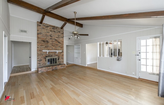 unfurnished living room with visible vents, a brick fireplace, vaulted ceiling with beams, light wood-style floors, and a ceiling fan