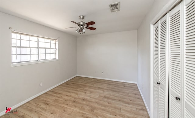 unfurnished bedroom with a closet, visible vents, light wood-type flooring, and baseboards