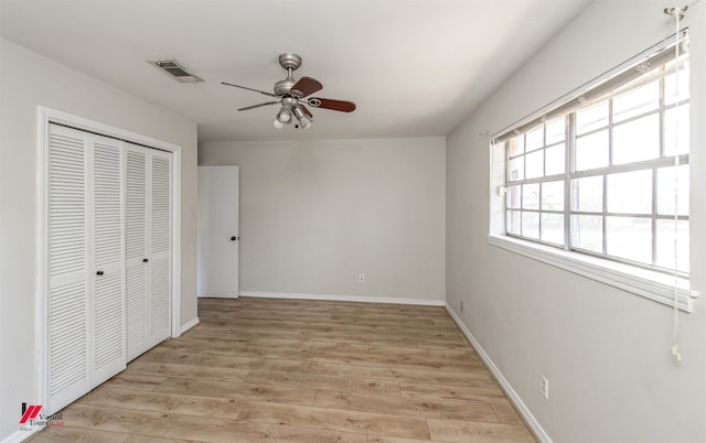 unfurnished bedroom featuring light wood-type flooring, visible vents, baseboards, and a closet