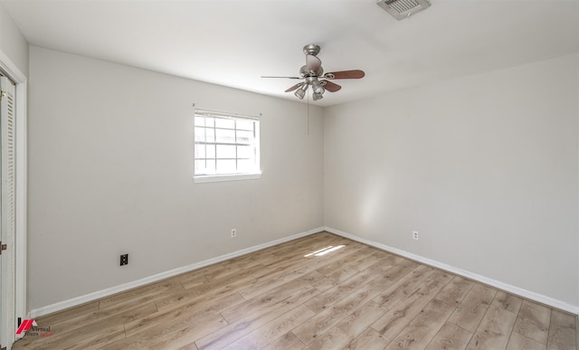 unfurnished bedroom featuring wood finished floors, visible vents, baseboards, ceiling fan, and a closet