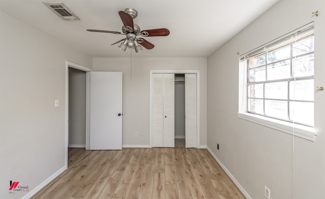 unfurnished bedroom featuring baseboards, visible vents, a closet, and light wood-type flooring