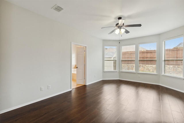 empty room with baseboards, visible vents, dark wood-style flooring, and ceiling fan