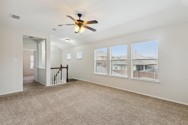 unfurnished room with visible vents, carpet flooring, baseboards, ceiling fan, and vaulted ceiling