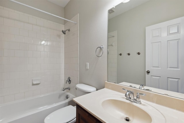 bathroom with toilet, vanity, shower / bathing tub combination, and a textured wall