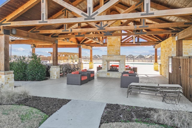 view of patio featuring a gazebo and an outdoor living space with a fireplace