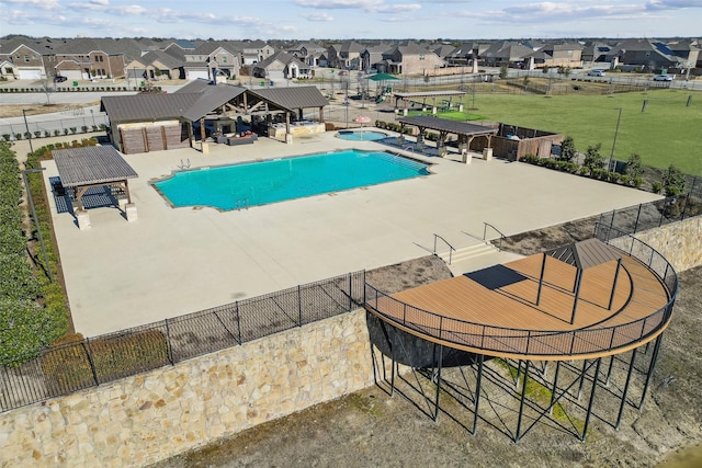 community pool featuring a gazebo, a residential view, a hot tub, and fence