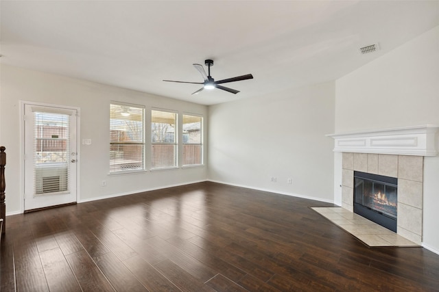 unfurnished living room with a ceiling fan, wood finished floors, baseboards, visible vents, and a fireplace