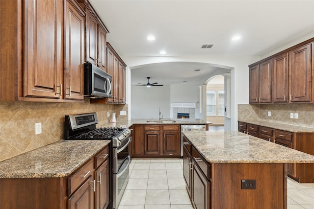 kitchen featuring visible vents, light tile patterned flooring, stainless steel appliances, a ceiling fan, and a sink