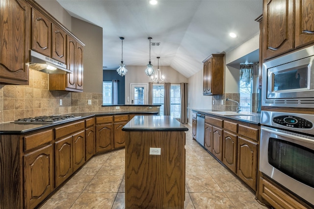 kitchen featuring under cabinet range hood, a sink, a center island, stainless steel appliances, and a peninsula