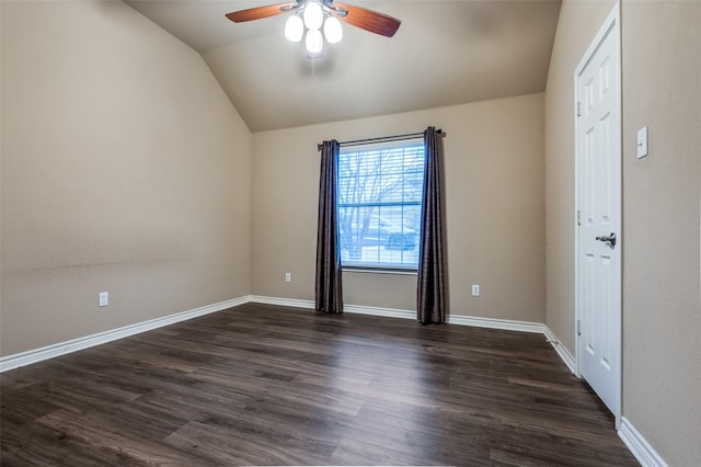 spare room with dark wood finished floors, ceiling fan, baseboards, and vaulted ceiling