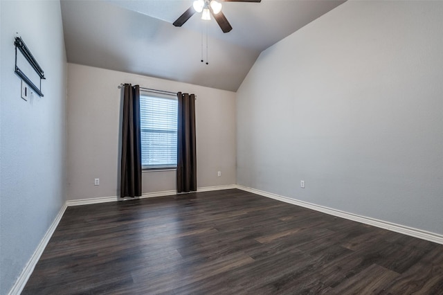 empty room featuring ceiling fan, baseboards, dark wood finished floors, and vaulted ceiling