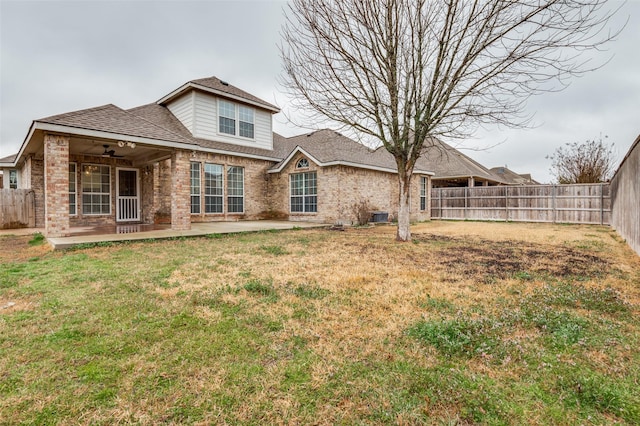 back of house featuring a lawn, a fenced backyard, cooling unit, brick siding, and a patio area