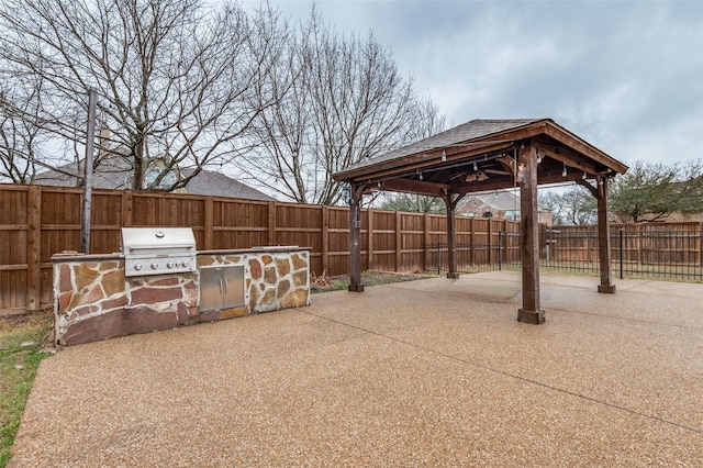 view of patio / terrace featuring an outdoor kitchen, a gazebo, a fenced backyard, and a grill