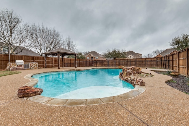 view of pool featuring a fenced in pool, exterior kitchen, a gazebo, a fenced backyard, and a patio area