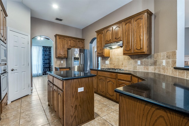 kitchen featuring under cabinet range hood, visible vents, appliances with stainless steel finishes, and arched walkways