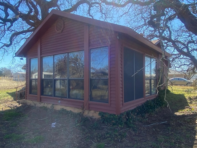 view of property exterior with a sunroom