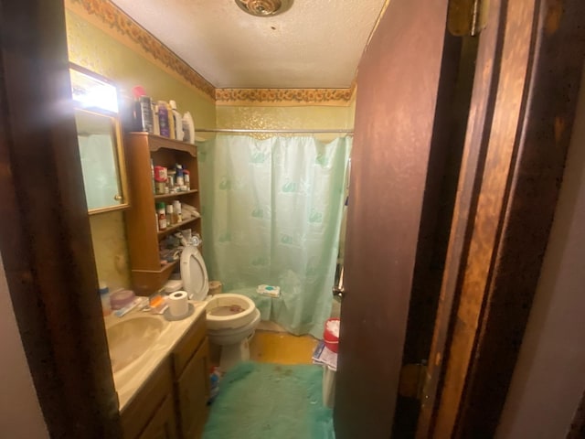 bathroom with curtained shower, a textured ceiling, toilet, and vanity