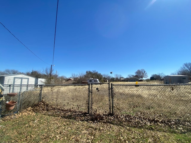 view of yard with a gate, an outbuilding, and fence