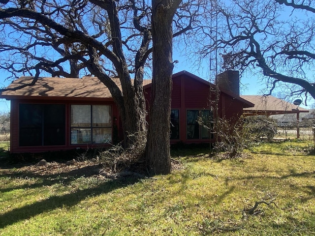 back of house with a lawn and a chimney