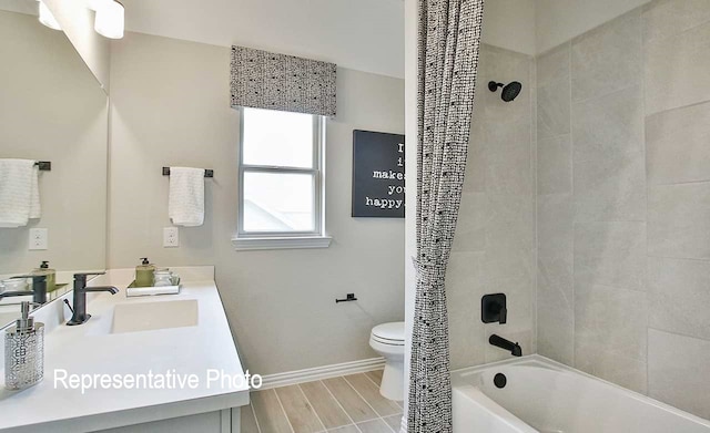 bathroom featuring vanity, baseboards, wood finish floors, shower / bath combination with curtain, and toilet