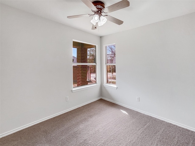 carpeted spare room with baseboards and ceiling fan