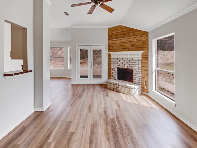 unfurnished living room featuring visible vents, a brick fireplace, vaulted ceiling, and light wood finished floors