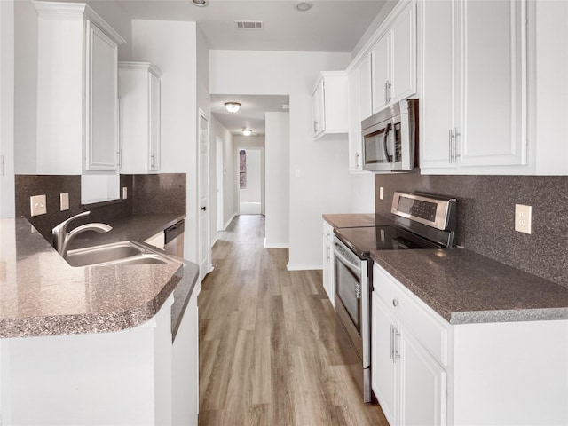 kitchen featuring a sink, visible vents, appliances with stainless steel finishes, and white cabinetry