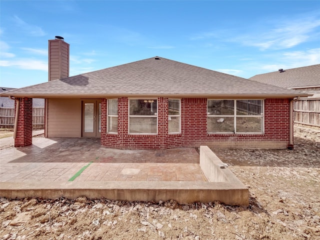 rear view of property featuring brick siding, a patio, and fence