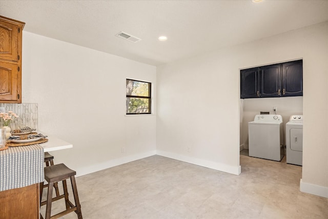 washroom with washing machine and dryer, recessed lighting, baseboards, visible vents, and cabinet space
