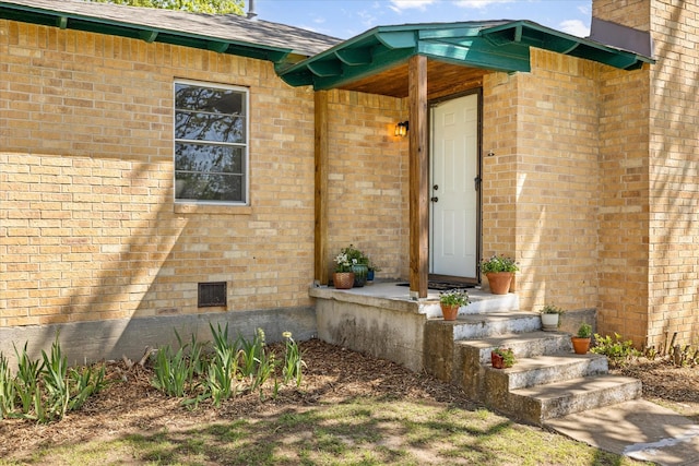 property entrance with brick siding and crawl space