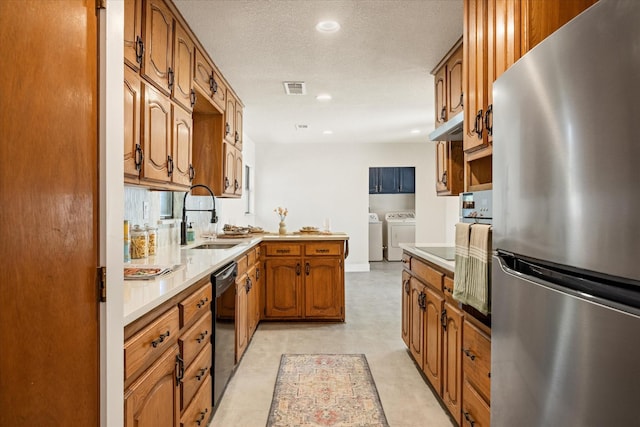 kitchen with a sink, a peninsula, independent washer and dryer, black appliances, and visible vents