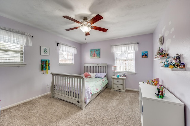 carpeted bedroom with baseboards and ceiling fan