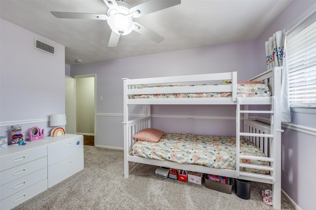 carpeted bedroom with visible vents, a ceiling fan, and baseboards