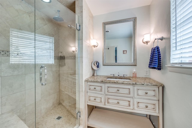 full bath with a stall shower and vanity